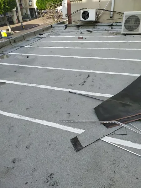 פועל מבצע איטום גג מקצועי עם ציוד מתקדם